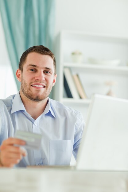 Hombre de negocios con tarjeta de crédito y cuaderno en su homeoffice