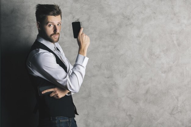 hombre de negocios, con, teléfono celular, arma de fuego