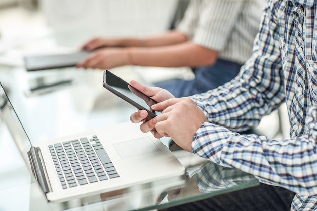 .hombre de negocios con un teléfono inteligente sentado en su escritorio.