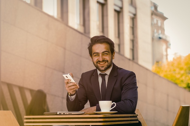 Hombre de negocios mediante teléfono móvil al aire libre.