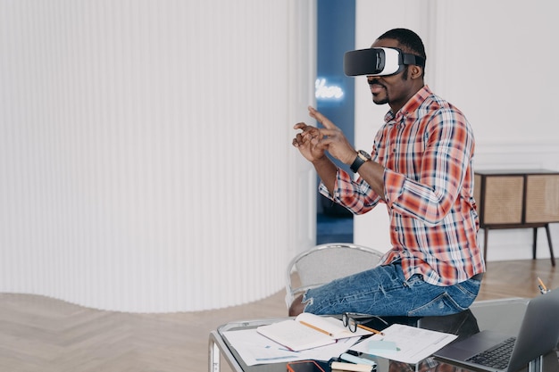 El hombre de negocios tiene un curso virtual El hombre afroamericano está usando gafas vr en casa