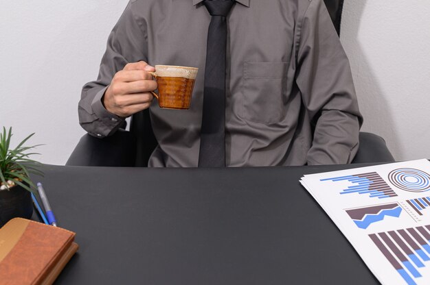 Un hombre de negocios tomando café en su escritorio