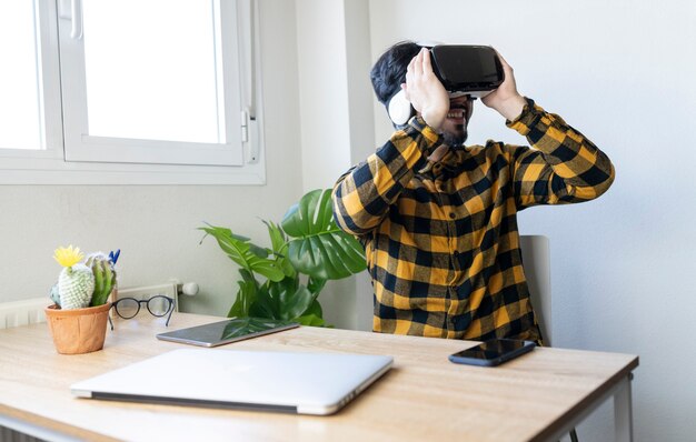 Hombre de negocios trabaja con gafas de realidad virtual en su brillante oficina