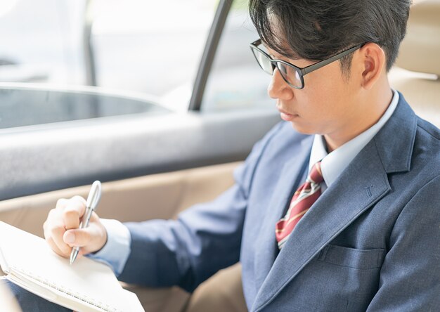 Hombre de negocios trabajando en el asiento trasero de un automóvil