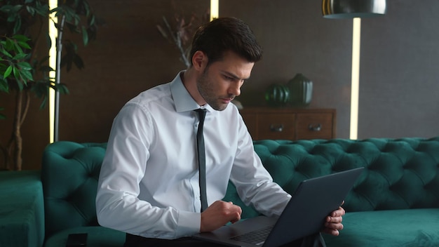 Hombre de negocios trabajando en la computadora portátil en el interior Gerente masculino apuntando al gráfico en la pantalla
