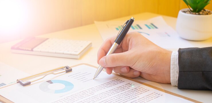 Hombre de negocios trabajando con datos financieros - lápiz en mano