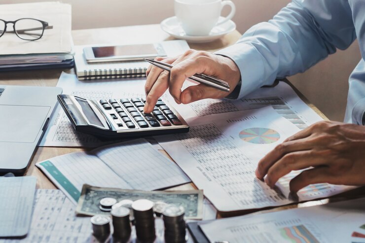 Foto hombre de negocios trabajando en escritorio en la oficina con el uso de calculadora