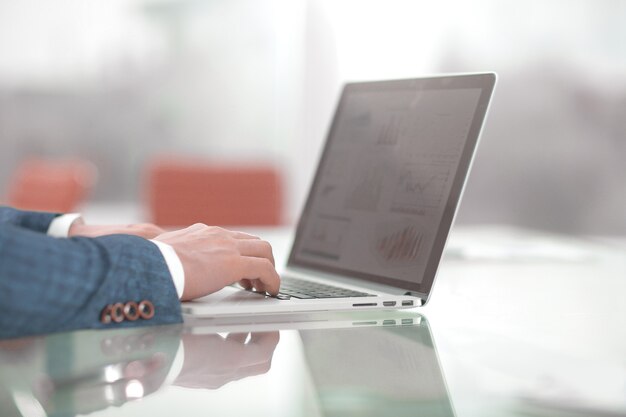 Foto hombre de negocios trabajando con gráficos financieros en la computadora portátil