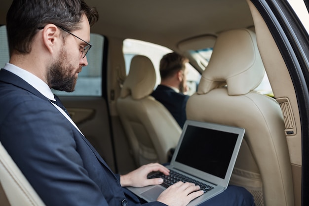 Hombre de negocios trabajando en línea en el auto