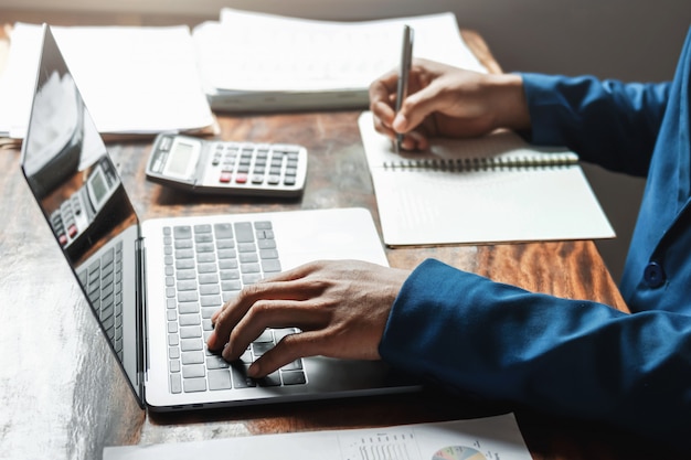 Hombre de negocios trabajando en la oficina con el uso de una calculadora para calcular el concepto de contabilidad financiera de números