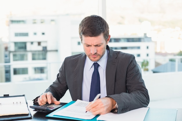 Hombre de negocios trabajando en sus finanzas en su escritorio