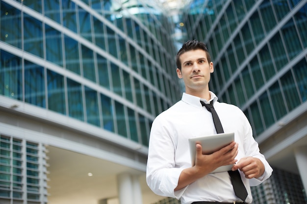 Hombre de negocios trabajando con tableta digital en entorno urbano