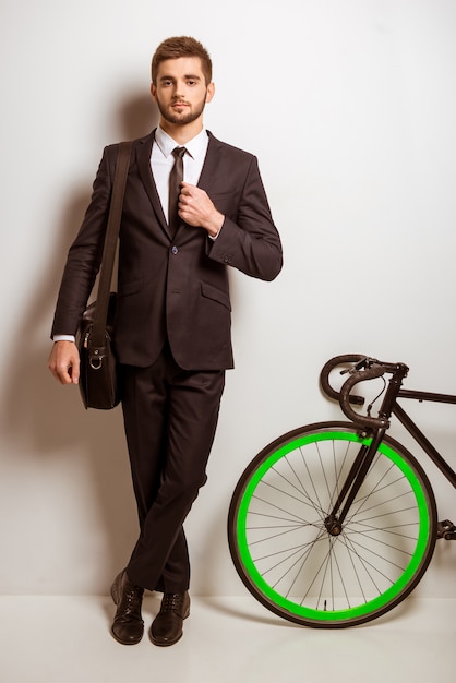 Hombre de negocios en un traje con una bicicleta.
