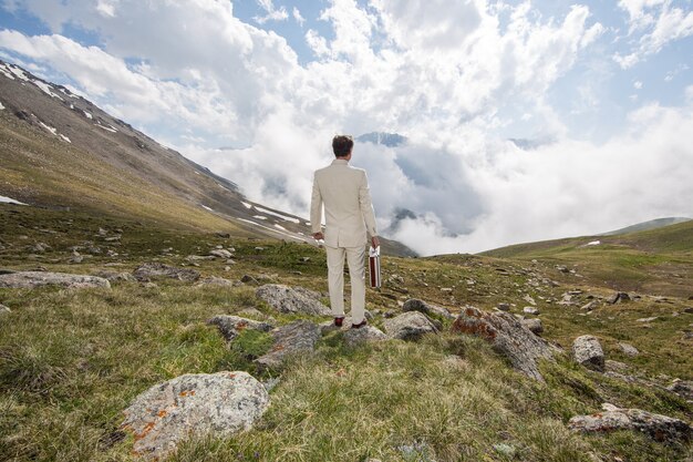 hombre de negocios, en, un, traje blanco, en las montañas