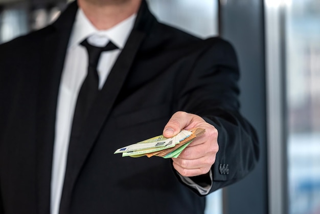 Hombre de negocios en traje negro clásico tiene dinero en euros Negocio de transacciones en efectivo