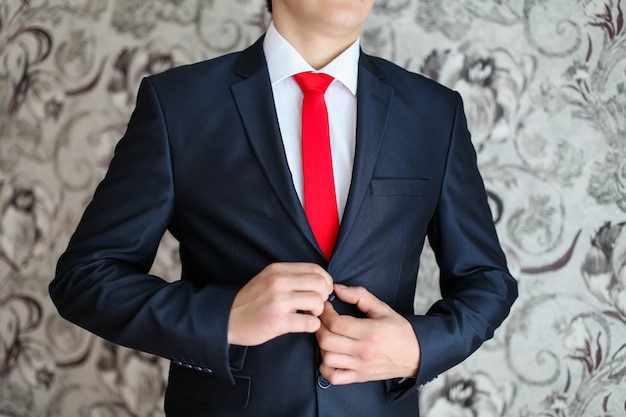 Foto hombre de negocios en traje negro y corbata roja.