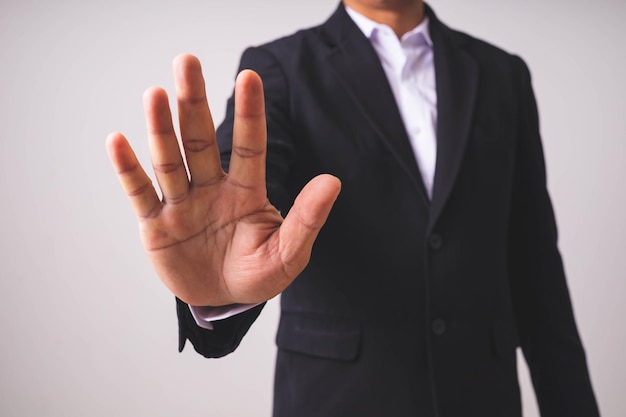 Foto un hombre de negocios con un traje negro se pone de pie y levanta las manos