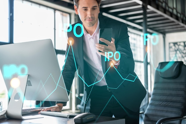 Foto hombre de negocios en traje que usa un teléfono inteligente para optimizar la estrategia de opi en finanzas corporativas gráfico holográfico sobre el moderno fondo panorámico de la oficina