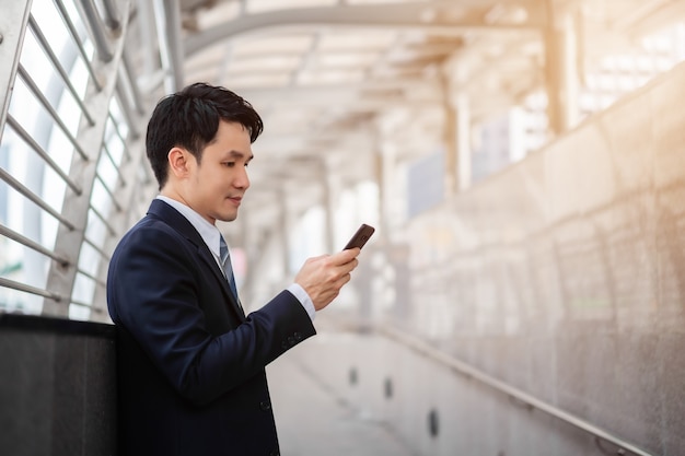 Hombre de negocios en traje con smartphone en la ciudad