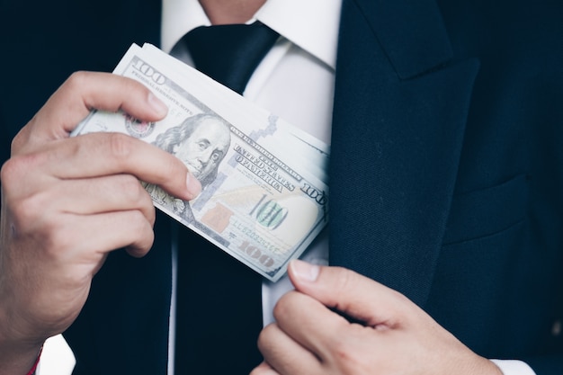 Foto hombre de negocios en trajes recibiendo gran cantidad de billetes en los estados unidos como un soborno