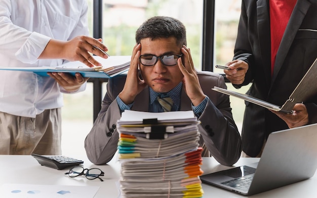 Hombre de negocios triste con exceso de trabajo con una pila de papeles, gente de negocios, estrés de plazo y concepto de papeleo