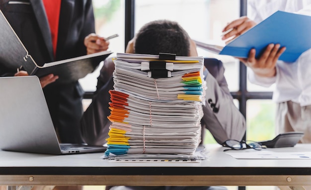 Hombre de negocios triste con exceso de trabajo con una pila de papeles, gente de negocios, estrés de plazo y concepto de papeleo