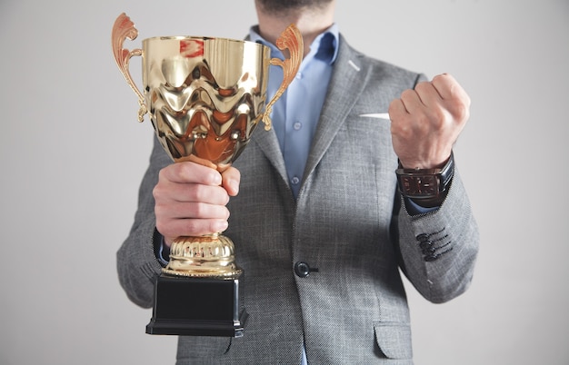 Hombre de negocios con trofeo de oro. Éxito en el negocio