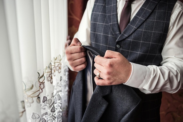 El hombre de negocios usa una chaqueta. El novio se prepara para la mañana antes de la ceremonia de la boda.