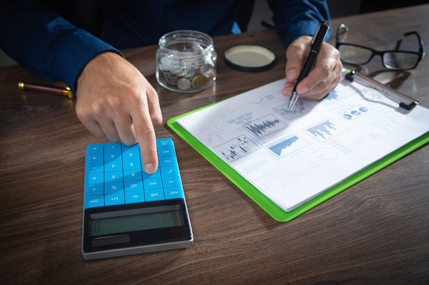 Hombre de negocios usando la calculadora para el plan de marketing de análisis