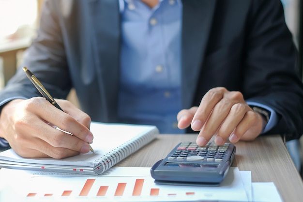 Hombre de negocios usando la calculadora para el plan de marketing de análisis