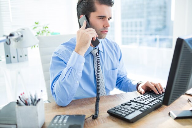 Hombre de negocios usando la computadora y llamando