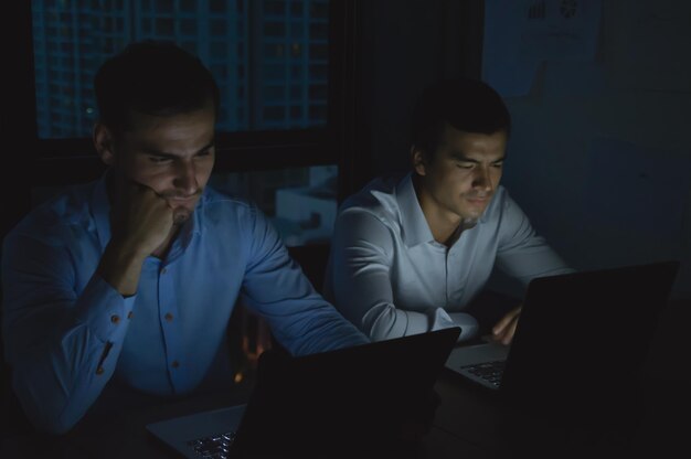 Foto un hombre de negocios usando una computadora portátil con un colega en la oficina