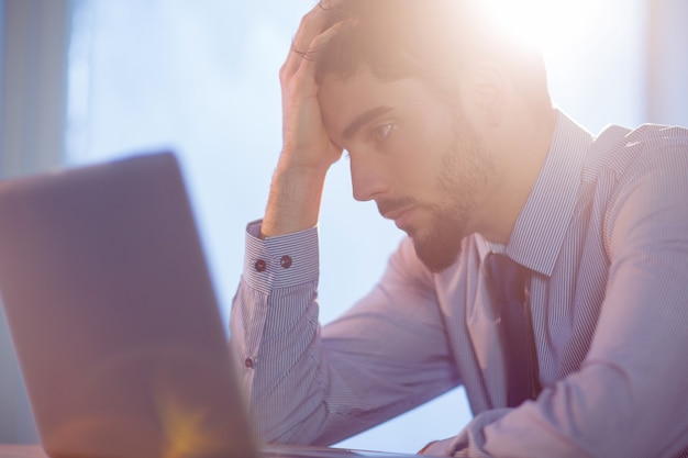 Hombre de negocios usando la computadora portátil en el escritorio