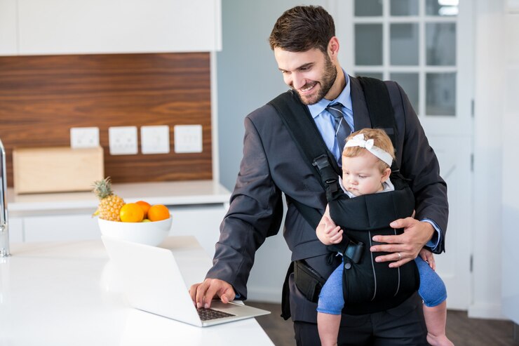 Hombre de negocios usando la computadora portátil mientras lleva a la niña