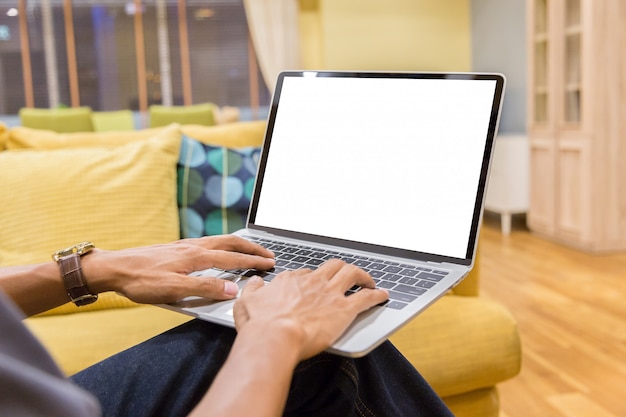 Hombre de negocios usando la computadora portátil con pantalla de escritorio blanco en blanco trabajando en casa