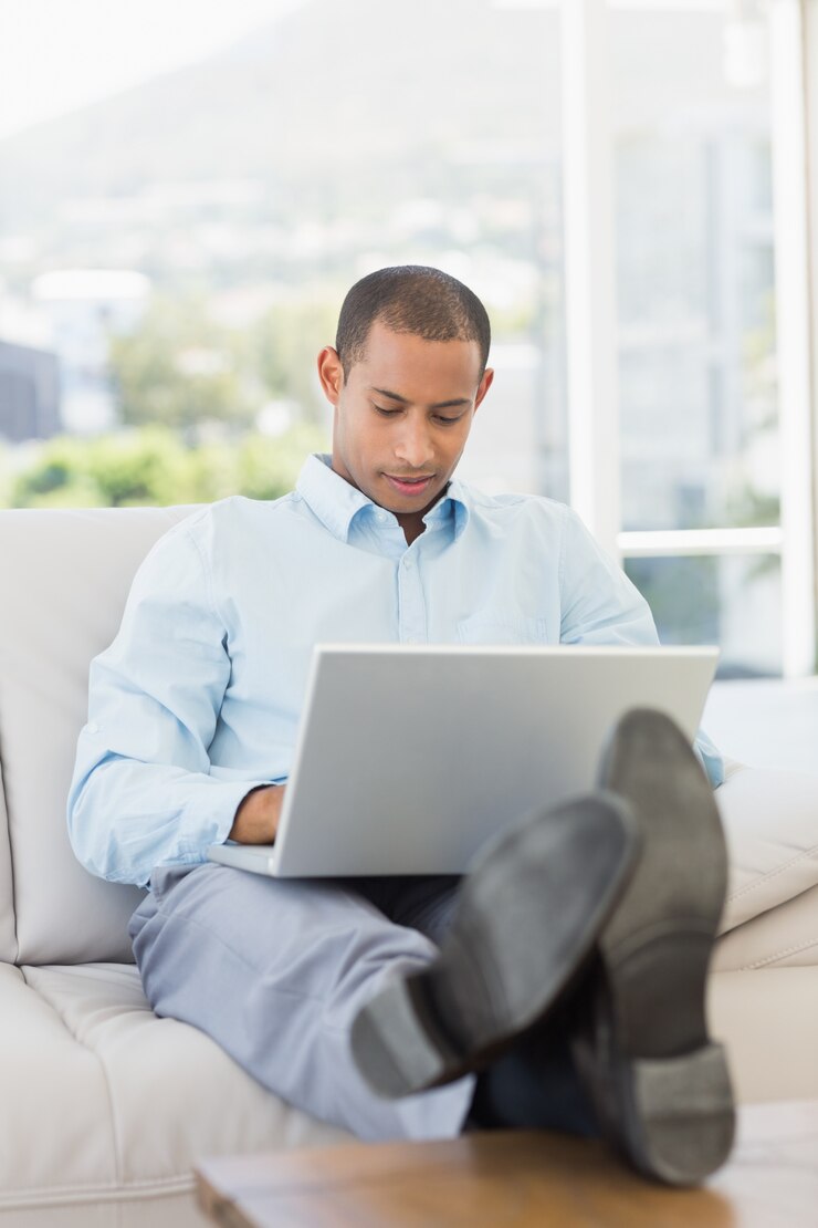 Foto hombre de negocios usando la computadora portátil con los pies en alto