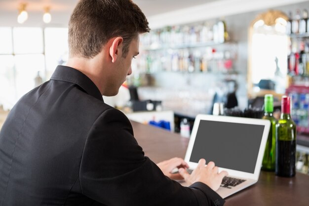 Hombre de negocios usando la computadora portátil en el restaurante