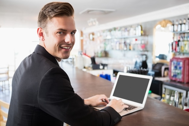 Hombre de negocios usando la computadora portátil en el restaurante