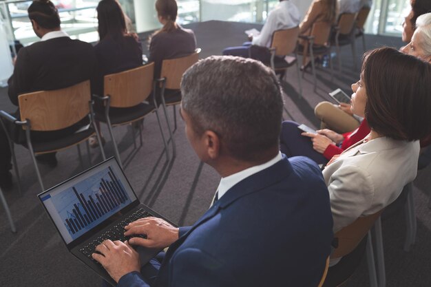 Foto hombre de negocios usando una computadora portátil durante un seminario de negocios