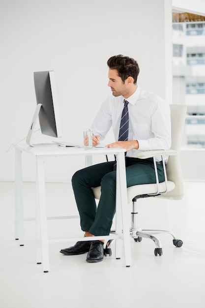 Hombre de negocios usando la computadora y tomar notas