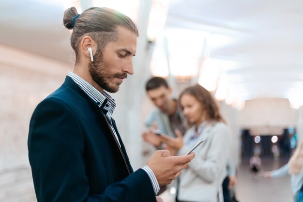 Hombre de negocios usando su teléfono inteligente en el metro