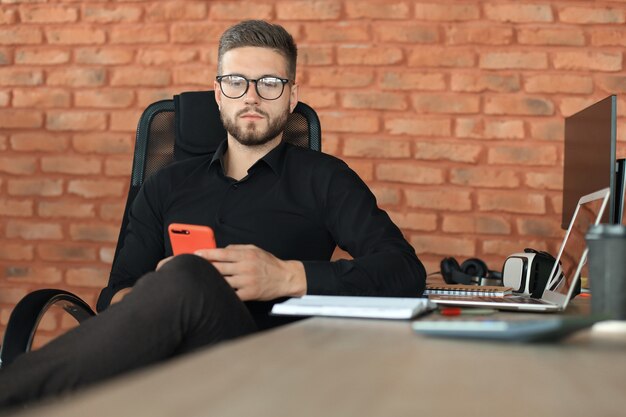 Hombre de negocios usando su teléfono móvil en la oficina.