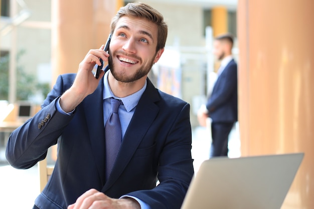 Hombre de negocios usando su teléfono móvil en la oficina.