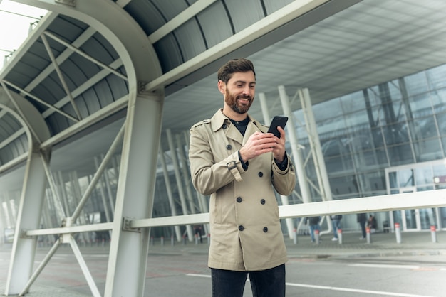 Hombre de negocios usando teléfono inteligente mientras camina