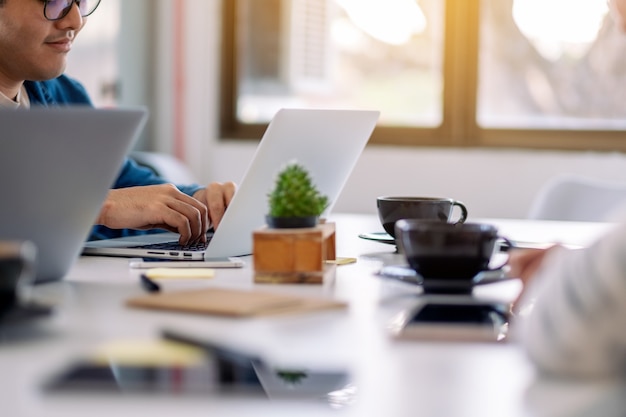 Hombre de negocios usando y trabajando en equipo portátil juntos en la oficina