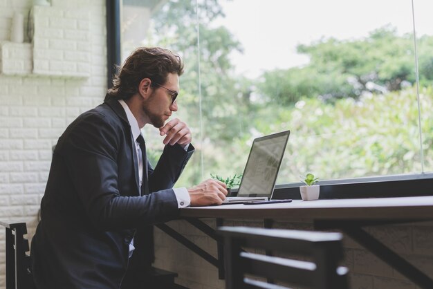 Hombre de negocios, usar la computadora portátil, en, café