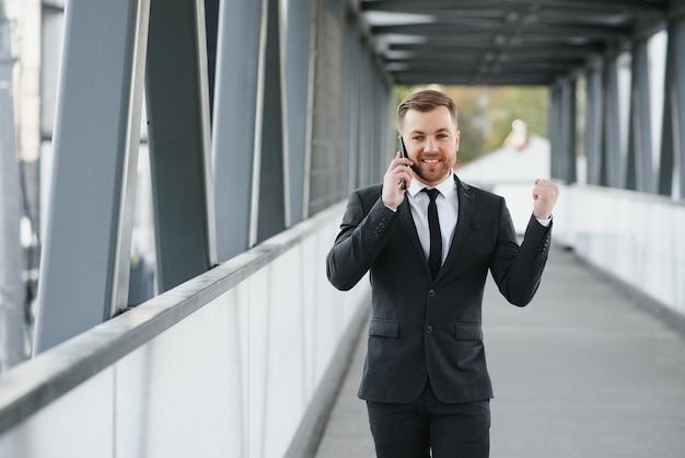 hombre de negocios, utilizar, smartphone, en, pasillo cubierto