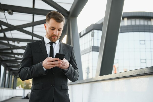 hombre de negocios, utilizar, smartphone, en, pasillo cubierto