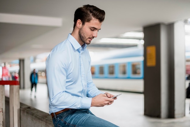 hombre de negocios, utilizar, teléfono celular, en, el, estación