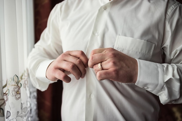 Foto el hombre de negocios viste camisa blanca manos masculinas closeupgroom preparándose en la mañana antes de la ceremonia de la boda